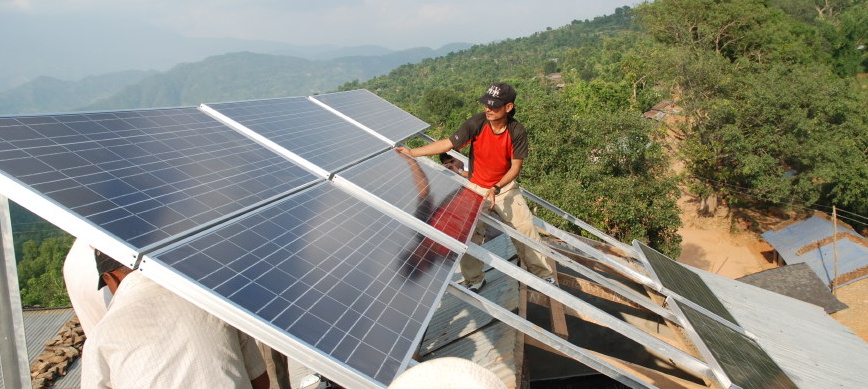 Enginners lift PhotoVoltaic panels into position on top of Shree Prabhat school in Dhawa, July 2010.